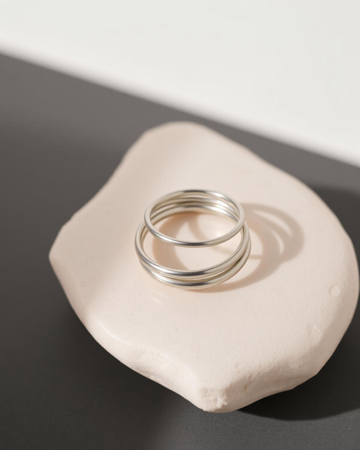 Plain silver stacking rings resting on pale stone